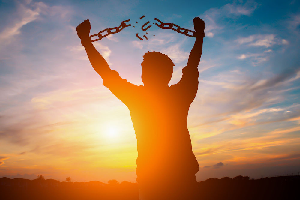 87173291 - silhouette image of a businessman with broken chains in sunset