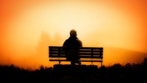 homme sur un banc au coucher de soleil