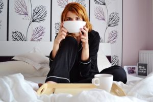 femme buvant dans son bol sur son lit